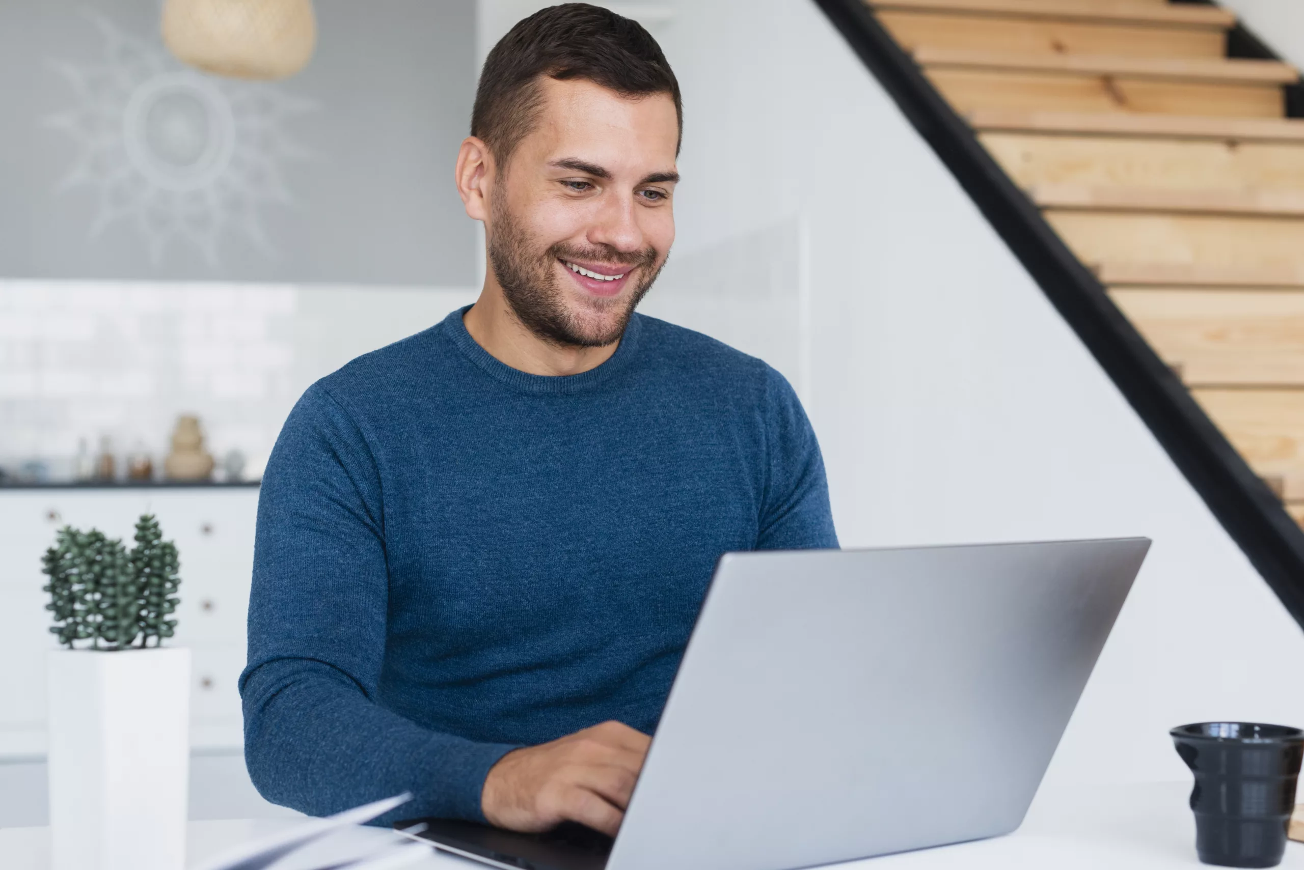 homem sentado e mexendo no computador fazendo um curso de educação corporativa