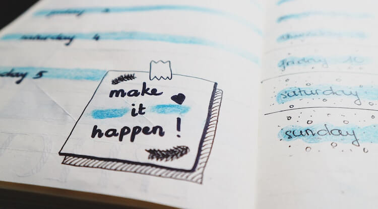 Um caderno aberto com algumas anotações de dias e um bilhete: make it happen!